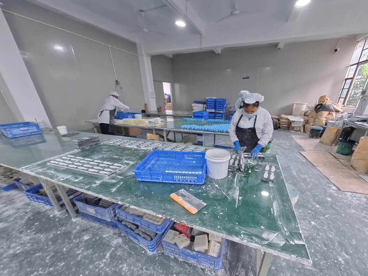 Workers Filling Diatomite Raw Materials Into Molds On Production Line
